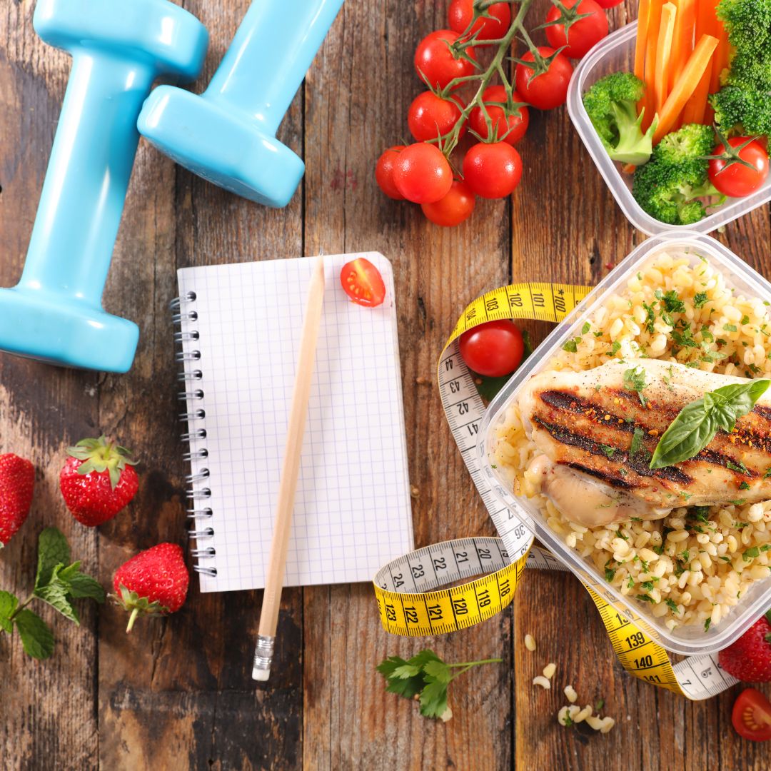 a table with healthy meals and hand weights